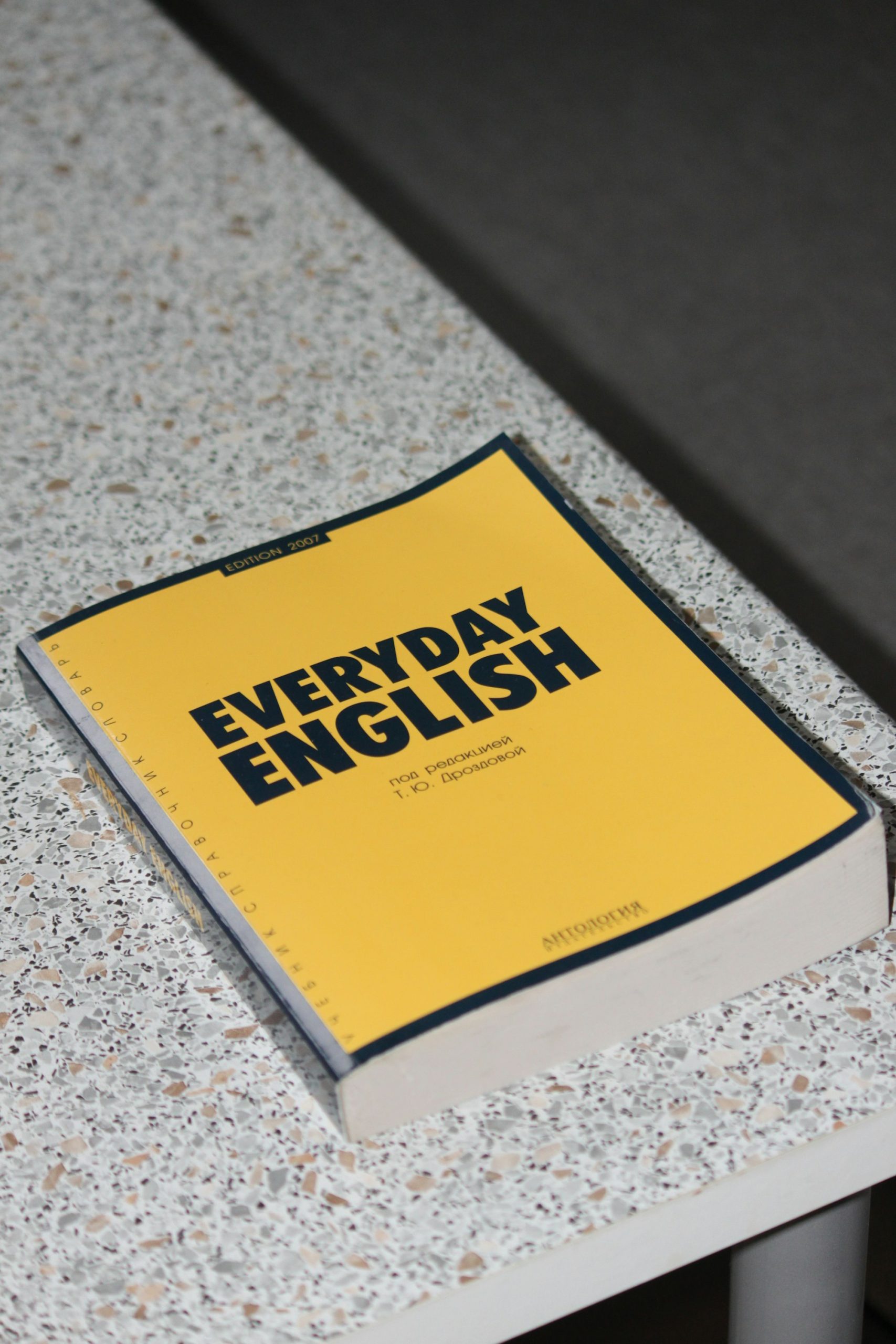 Livro de inglês do dia a dia sobre a mesa, representando o estudo com tutor de IA