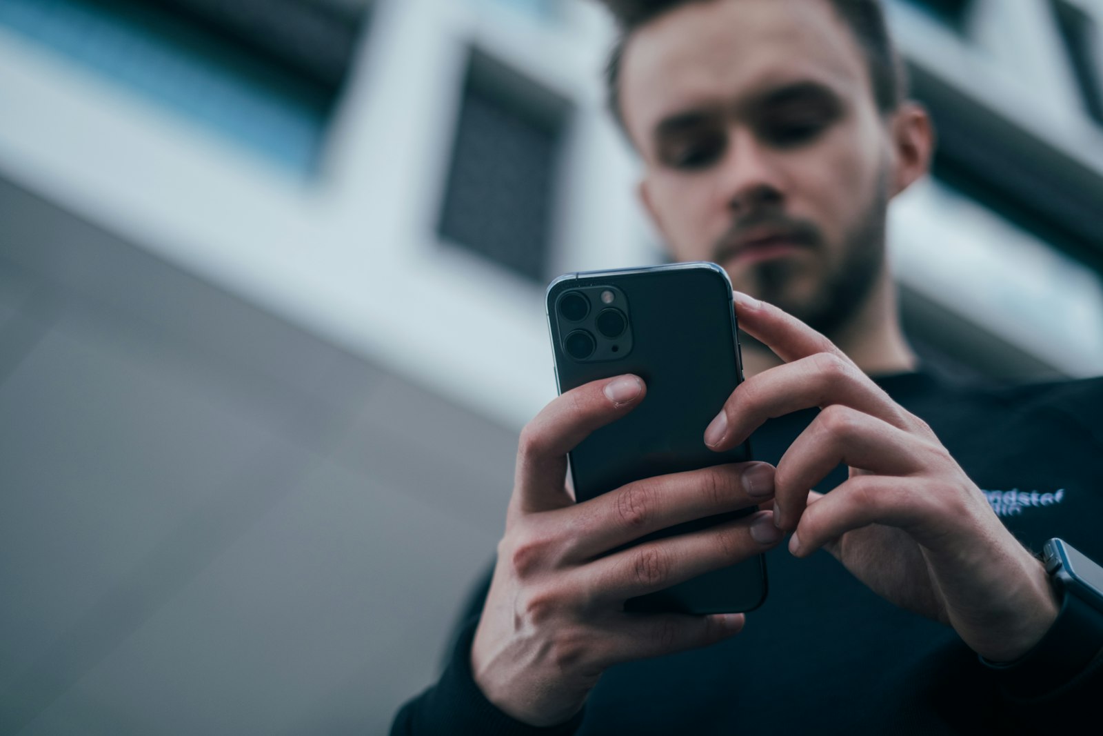 Homem respondendo mensagens de clientes pelo smartphone
