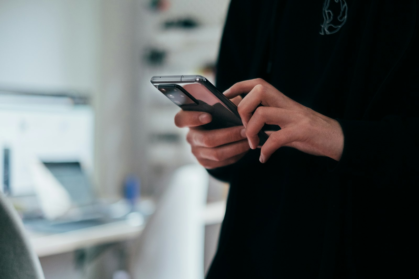 Pessoa segurando celular e digitando mensagem em aplicativo de conversa