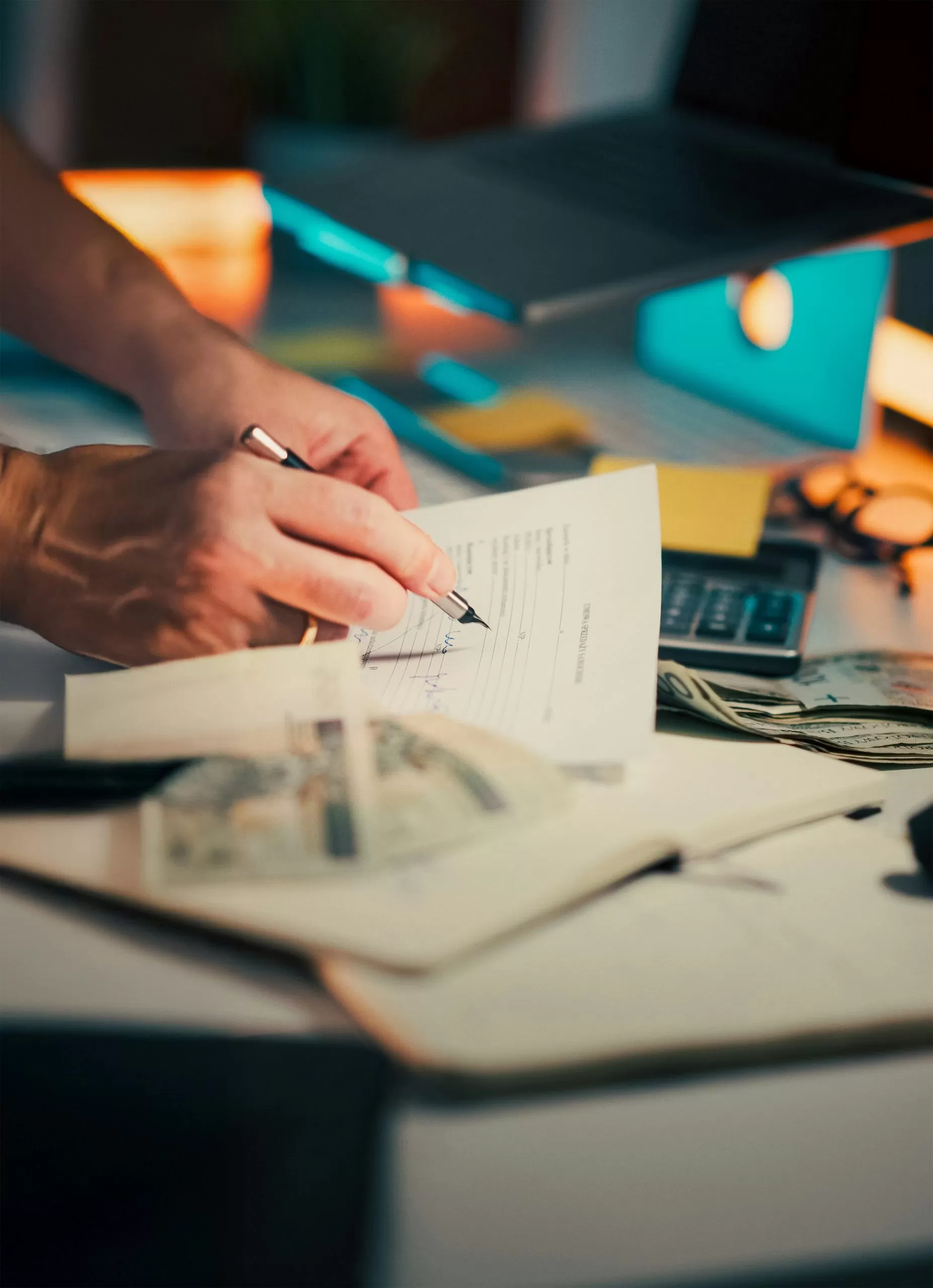 Mãos assinando um documento sobre a mesa durante renovação de contrato de software